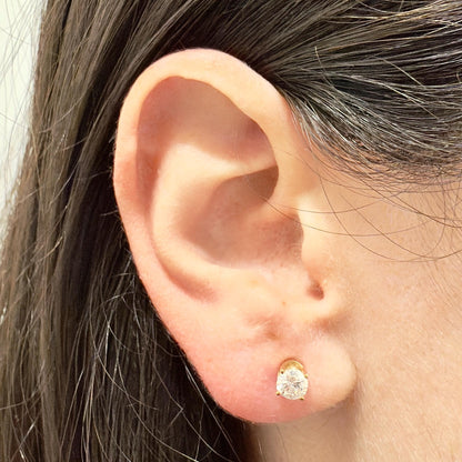 A pair of vintage 4-prong-set diamond stud earrings crafted in 14k yellow gold with push backs. It is set with 2 natural round diamonds weighing approx 1 carat (5-5.05 mm). The stones are approx F-G color SI2-I1 clarity. - WeilJewelry